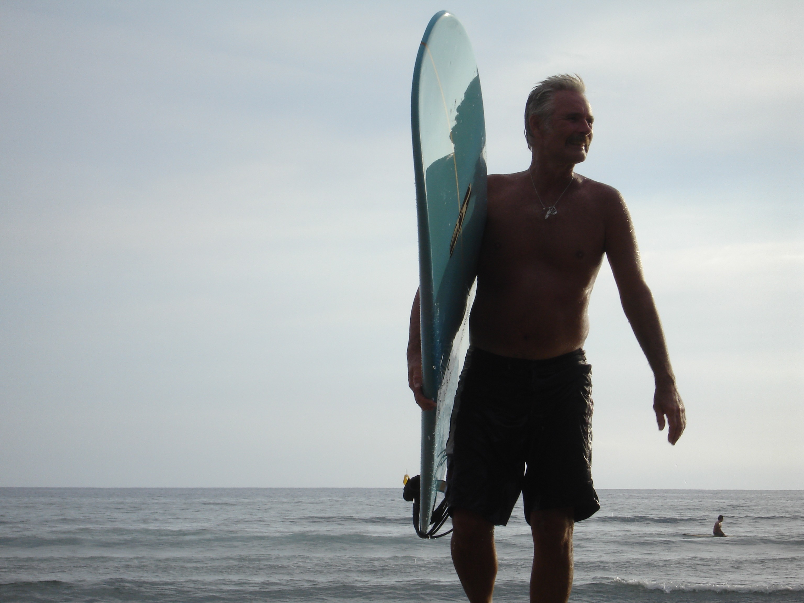 Photo of Mike with his surfboard.